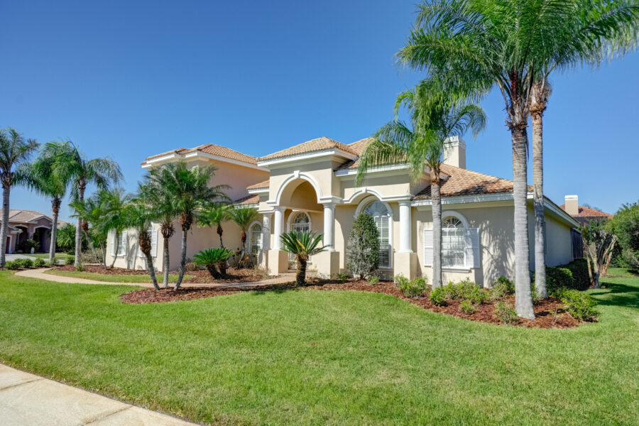 Beautiful luxury home with exceptional curb appeal in Cheval East, Lutz, Florida, featuring professional landscaping, manicured lawn, elegant architecture, inviting front entrance, and mature trees. Sold by Steve Scherpf with SSI Realty.